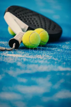 Blue padel court with sports equipment, padel racket and padel balls